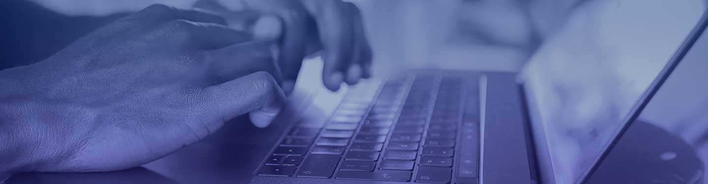 Close up of two hands typing on a laptop keyboard