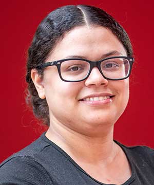 Headshot of Cerimar Olivares, a light-skinned Dominican-American woman with dark brown hair, brown eyes and black glasses. Turned slightly to the side, Cerimar smiles at the camera. 