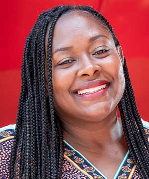 Headshot of Danna Lennon-Thomas, a black woman with long dark hair. Danna smiles directly at the camera.