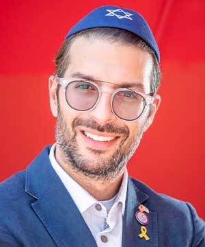 Headshot of Simon Sebag The Jewish Community Liaison for The Public Advocate. Arms crossed smiling directly at the camera.