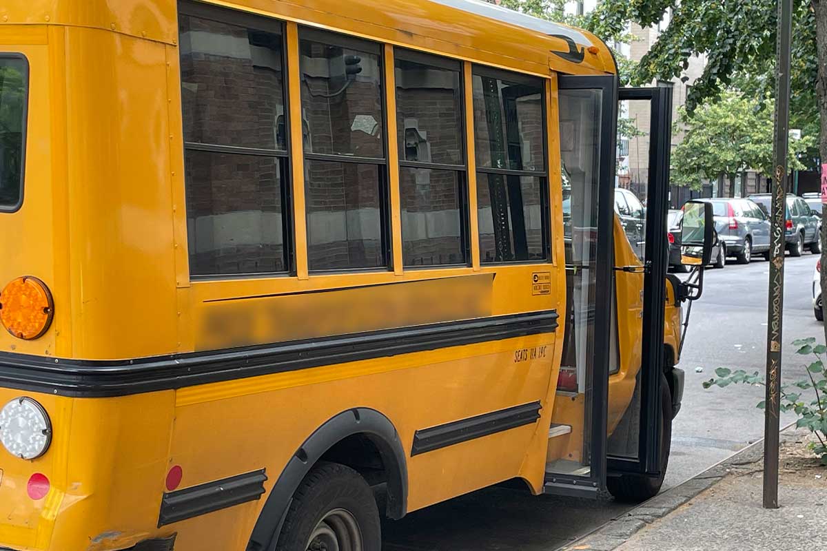 A side view of an NYC school bus with the front door open.