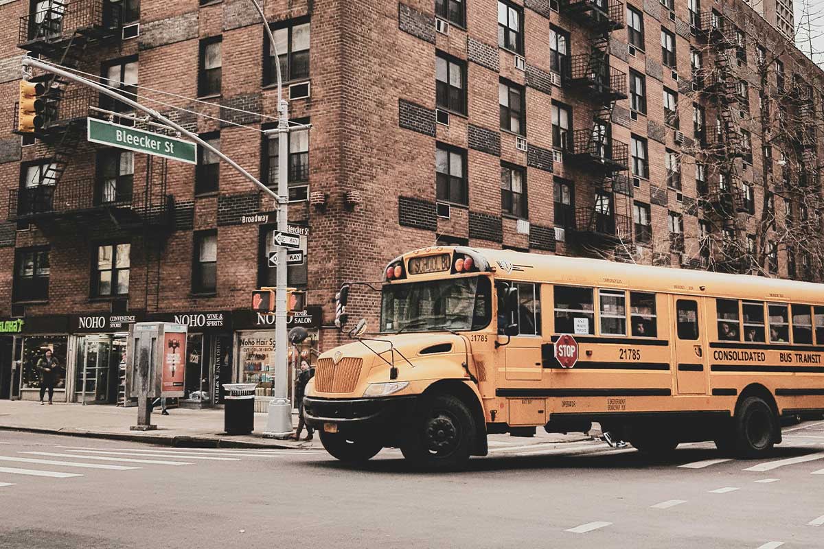 An NYC school bus on the corner of Broadway and Bleecker Street