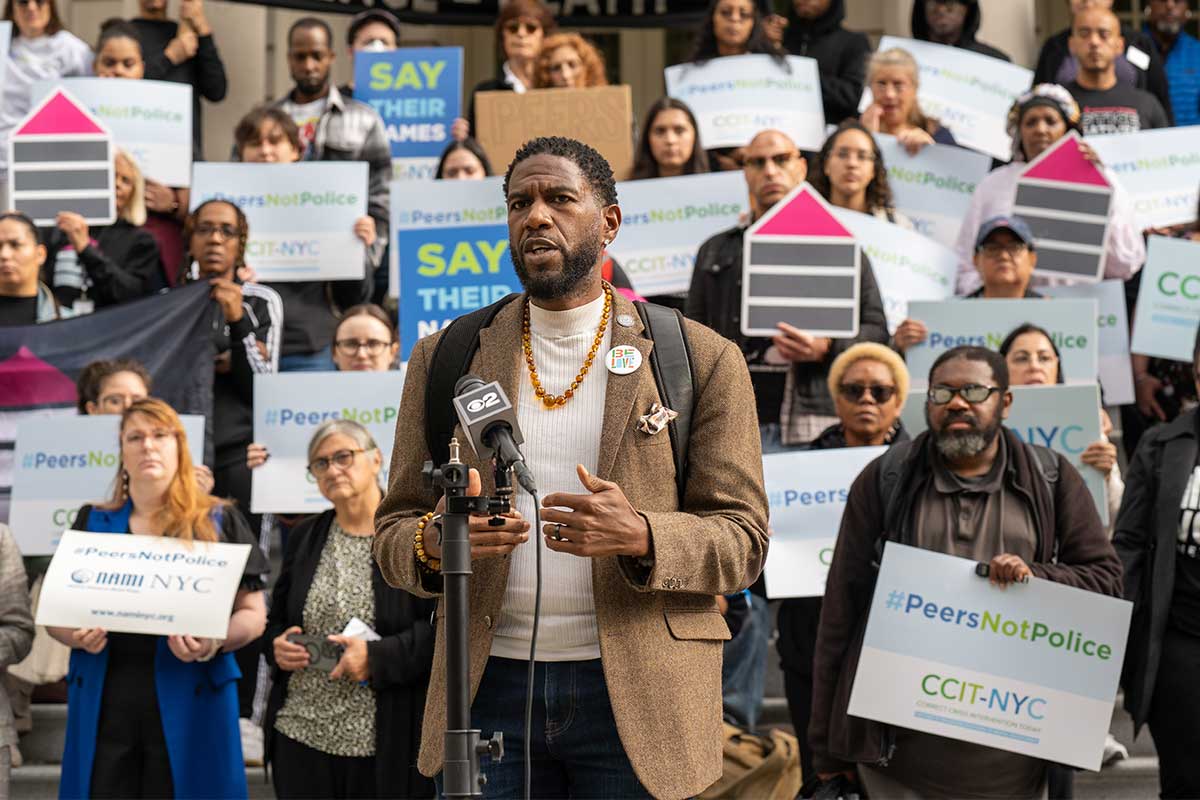 Photo of Public Advocate Jumaane D. Williams speaking in front of a #PeersNotPolice rally.